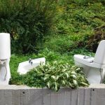 bilde av to toalett i en hage som skal plukkes opp for gjenbruk